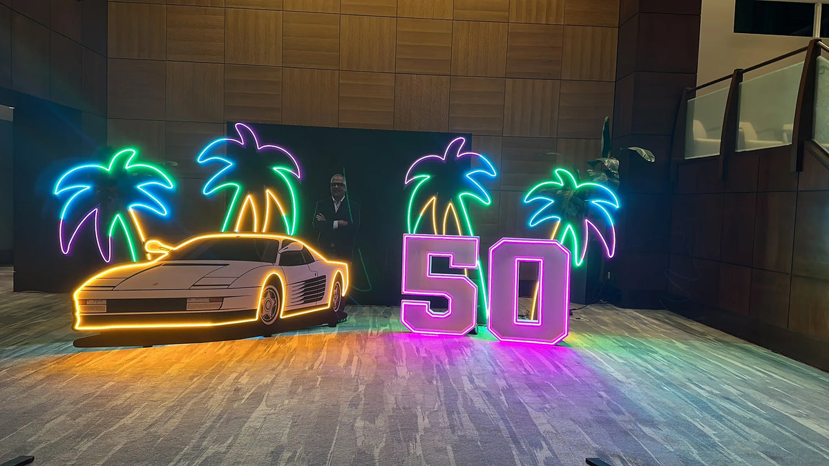 Neon palm tree, car, and 50th anniversary event installation