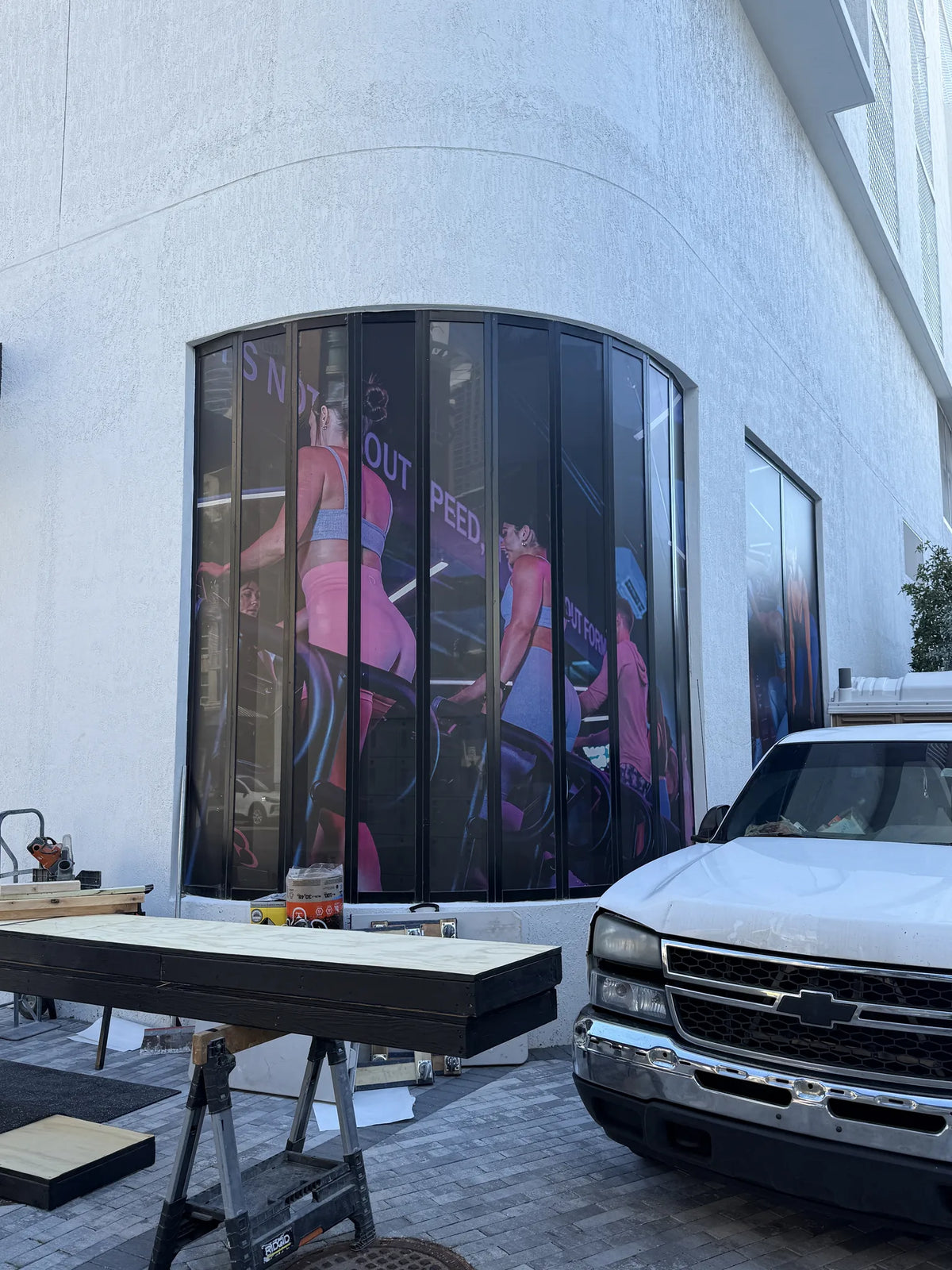 Large-format fitness imagery wrapped around curved exterior windows